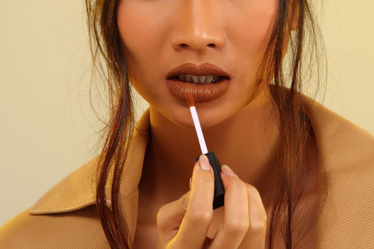 ragazza che applica tinta labbra