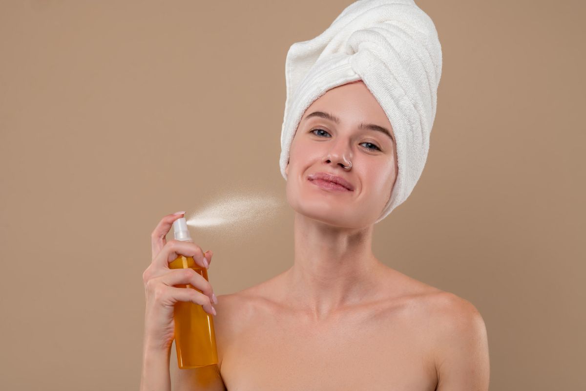 Donna con spray viso