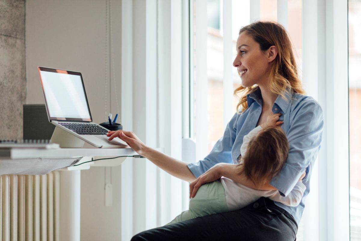 mamma al pc con bambino in braccio