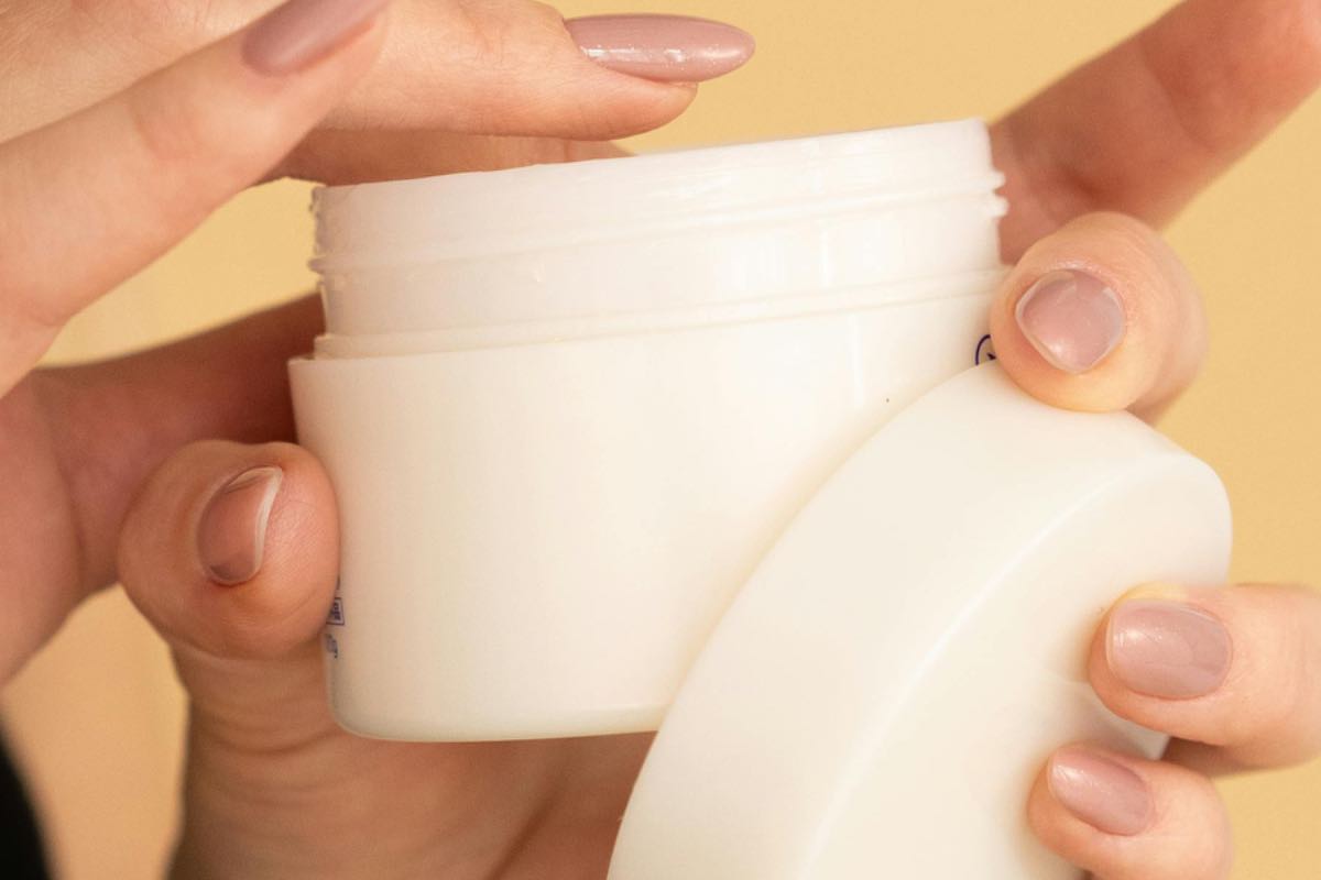 Donna che mette dita in crema