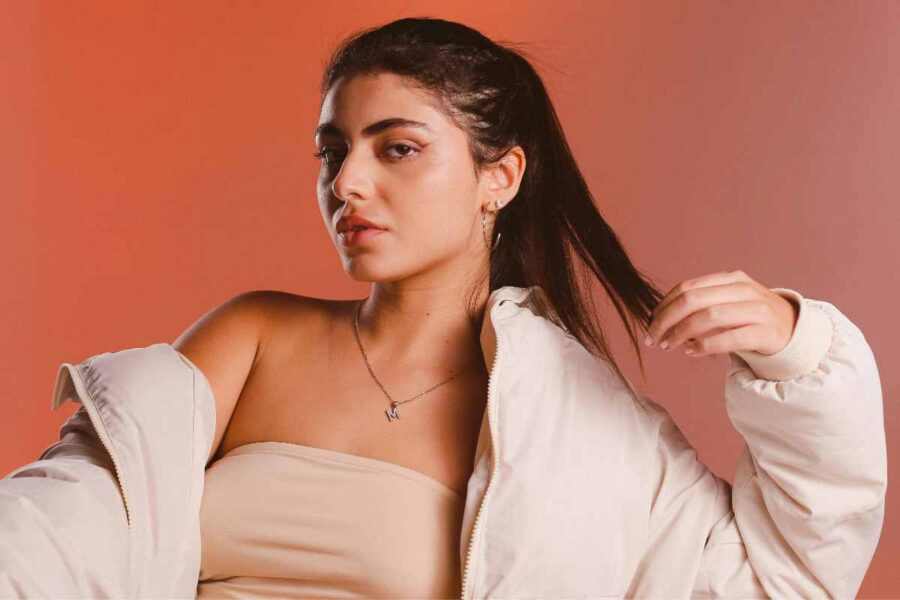 una ragazza indossa un piumino corto su un top senza spalline