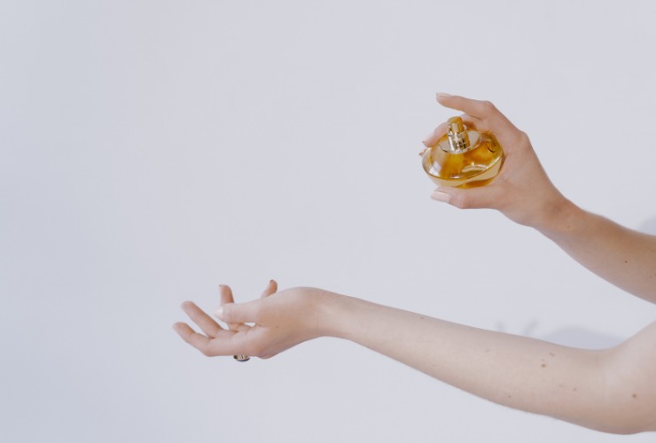 persona mette profumo su polso 