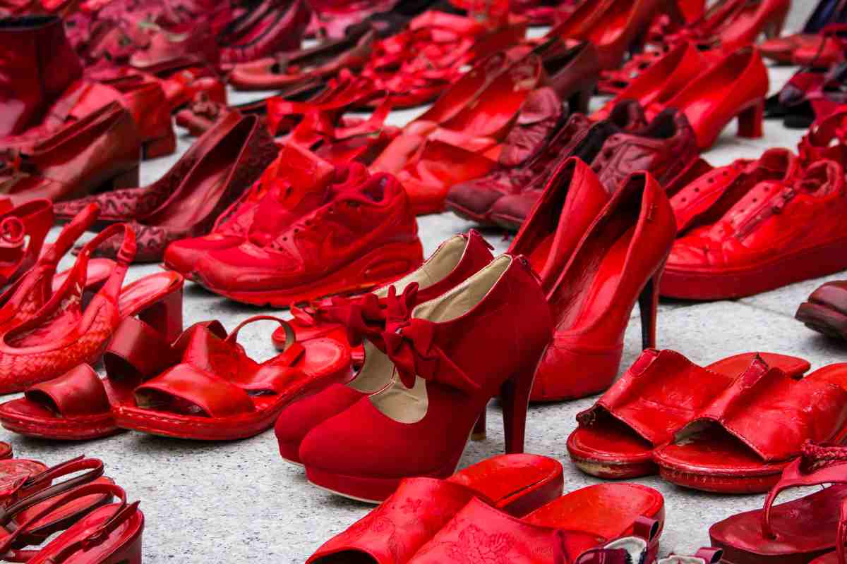 tante scarpe rosse sull'asfalto