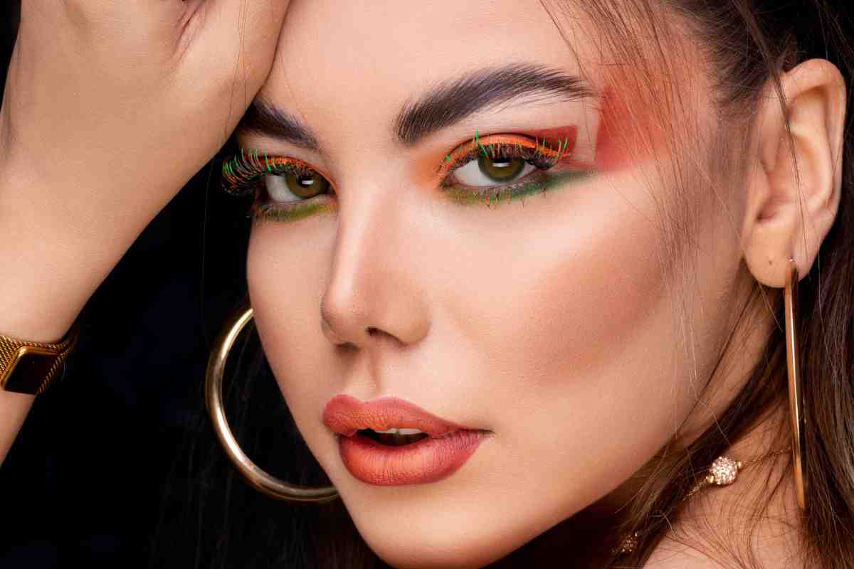 Viso di una ragazza con viso ovale che ha un trucco colorato