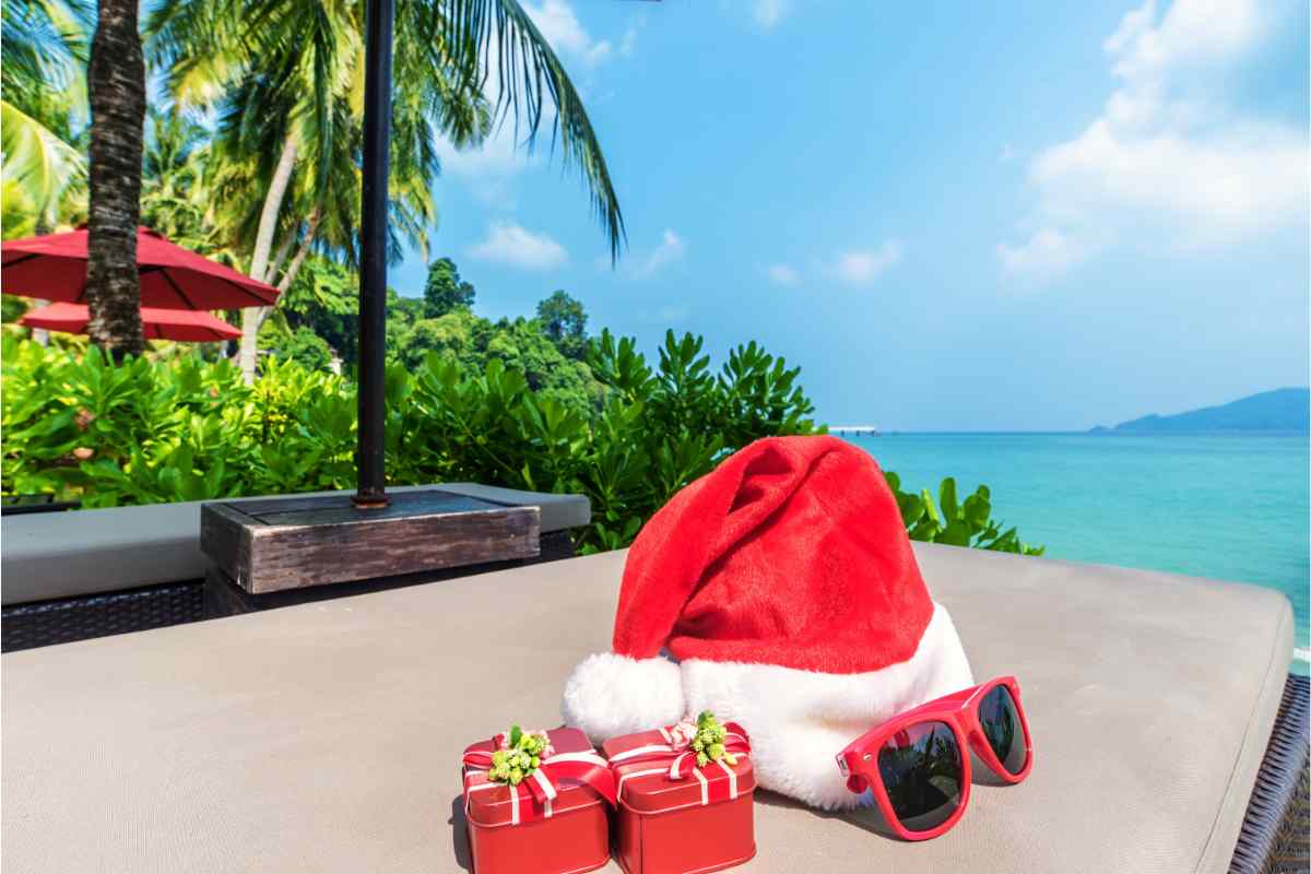 cappello di babbo natale e pacchetti regalo sullo sfondo il mare dei caraibi