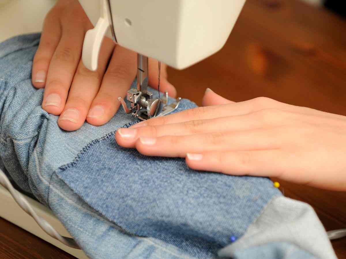 donna cuce a macchina un jeans