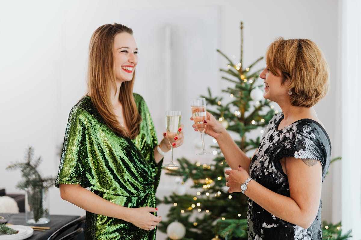 due donne che brindano a Natale con abiti paillettati