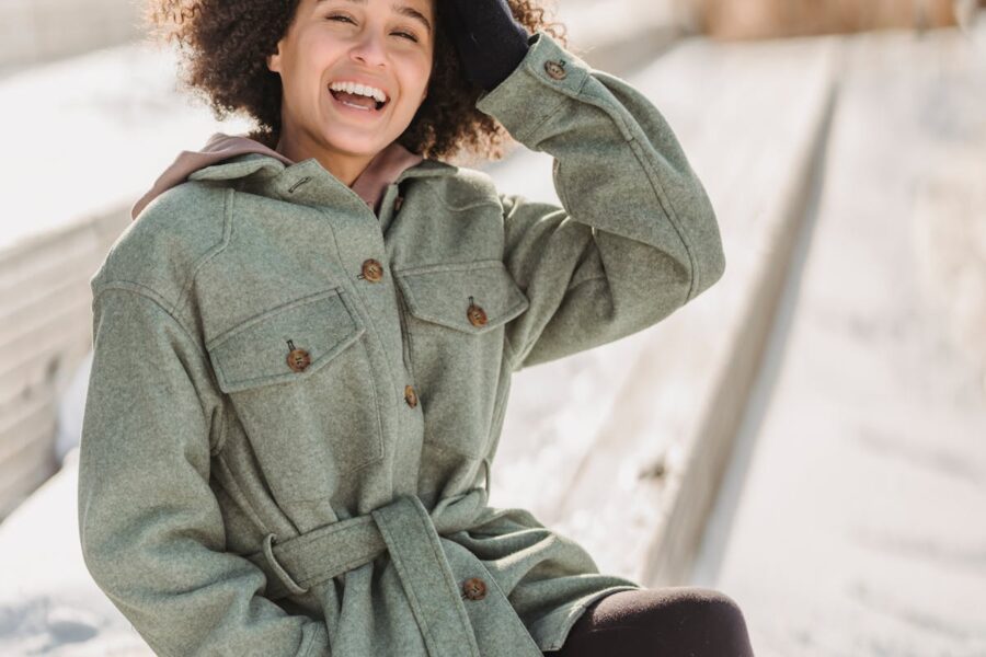 donna che sorride e indossa cappotto