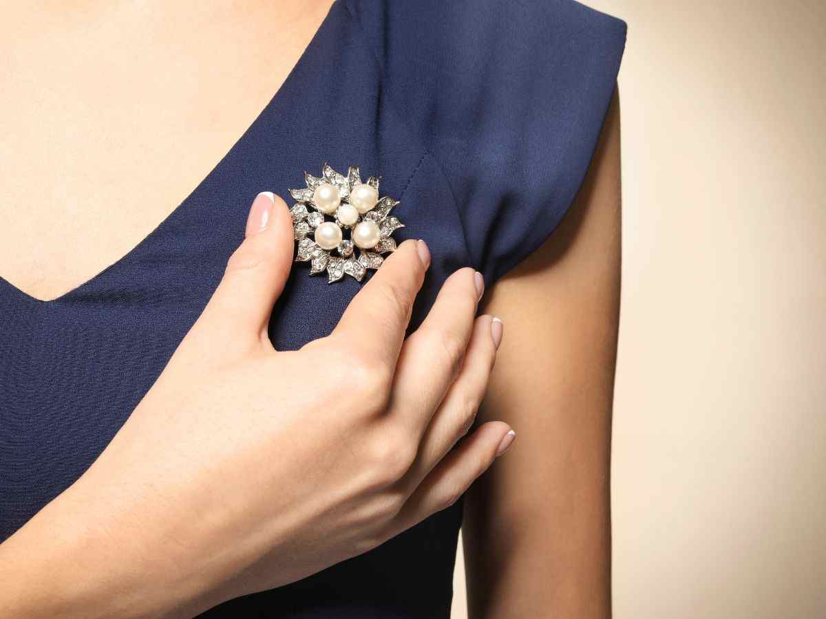 una donna tiene una spilla indossata sul vestito