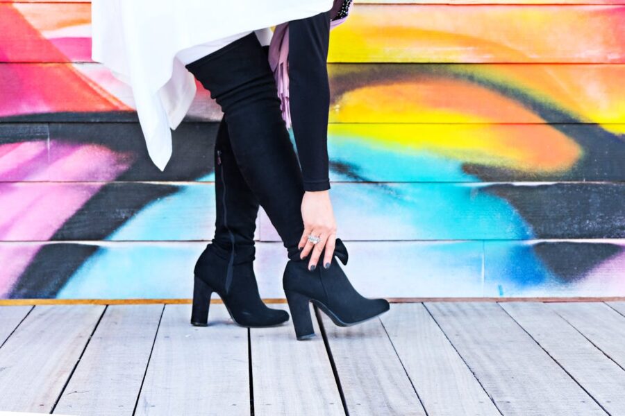 donna che si abbassa per sistemare stivali alti