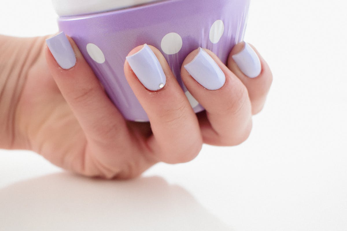 donna con unghie azzurre, mano in vista