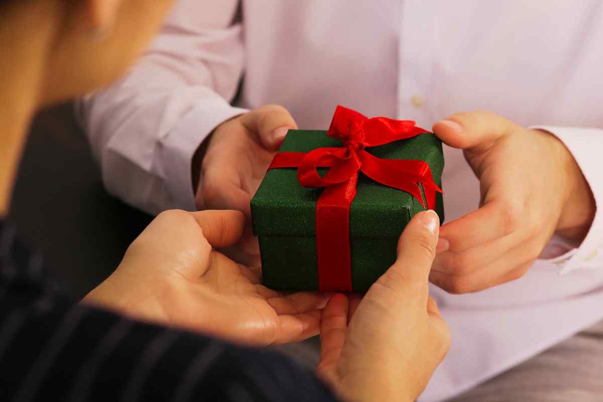 donna consegna un pacco regalo a un uomo