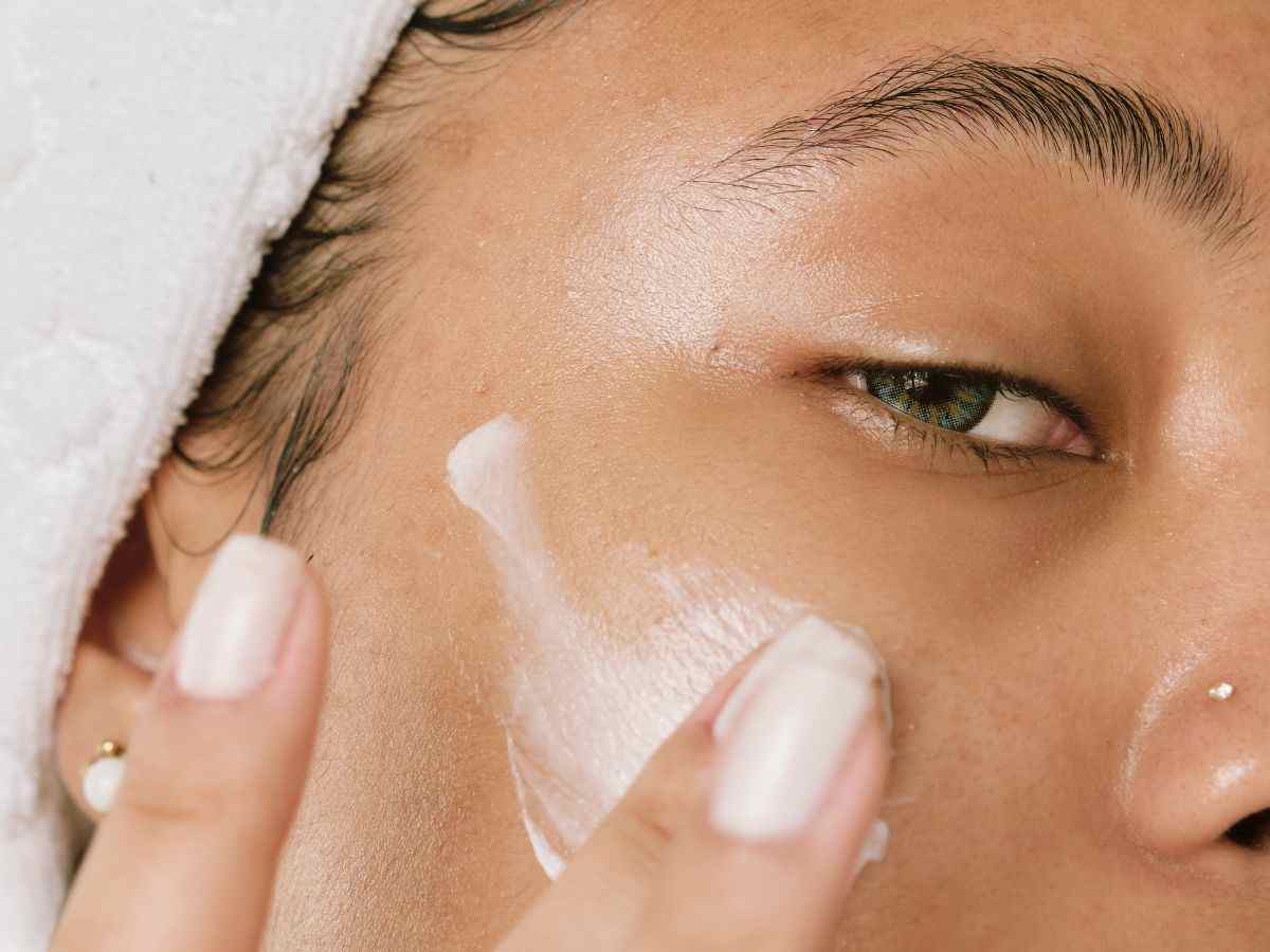 donna spalma crema sul viso