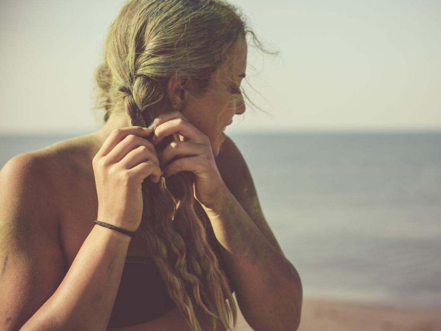 ragazza bionda intreccia la sua chioma