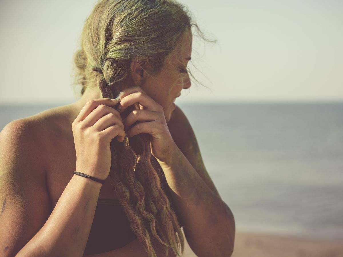 ragazza bionda intreccia la sua chioma