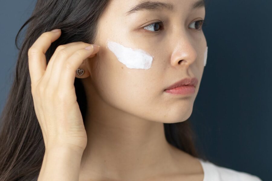 donna che mette crema viso