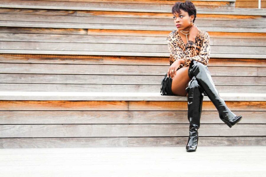 donna seduta su scale con stivali alti