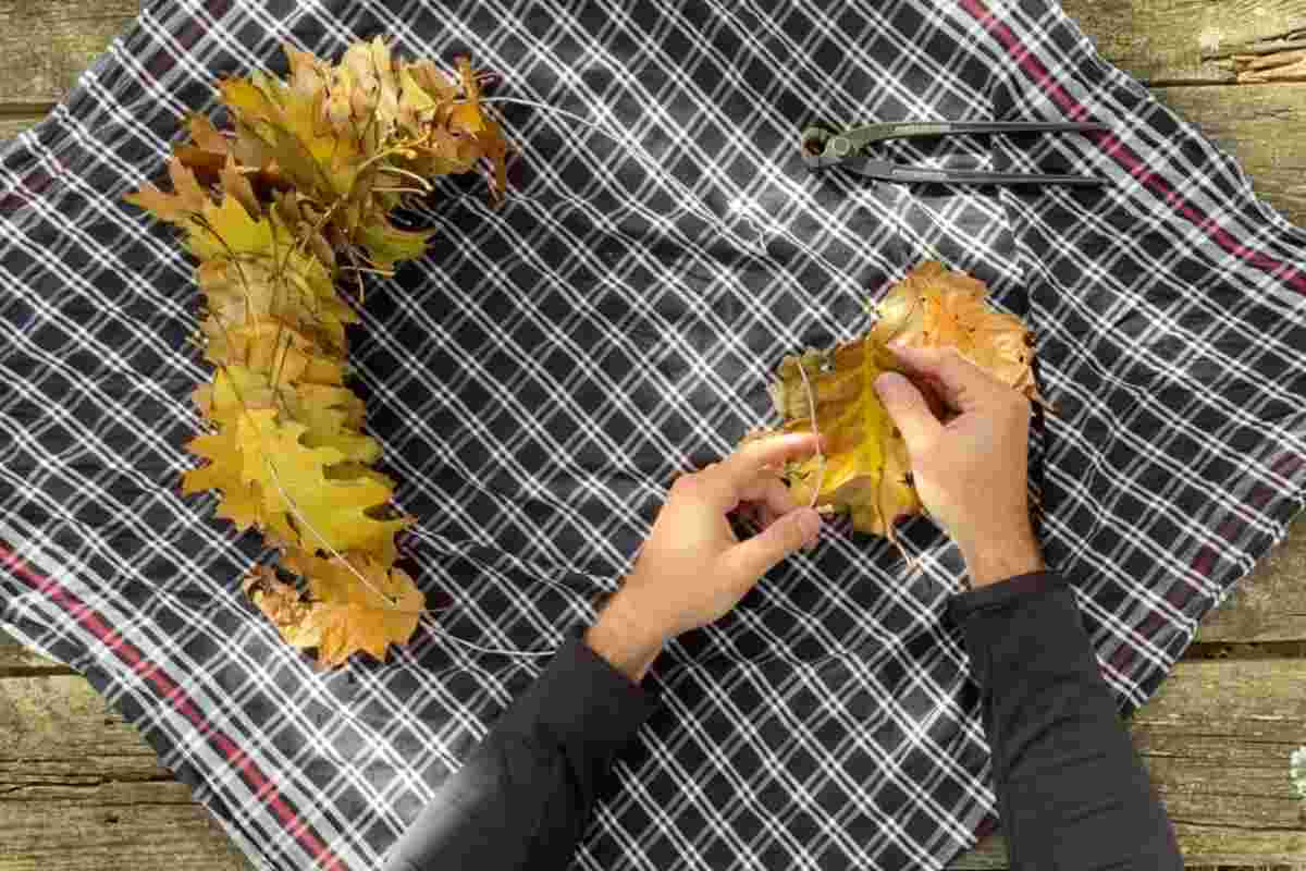 persona monta ghirlanda con foglie secche