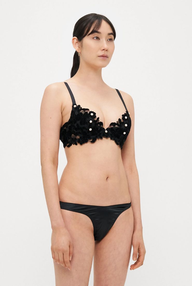 Donna con intimo nero e perle