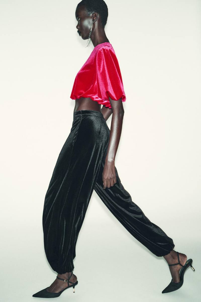 modella cammina e sfoggia pantalone nero in velluto a zampa di elefante