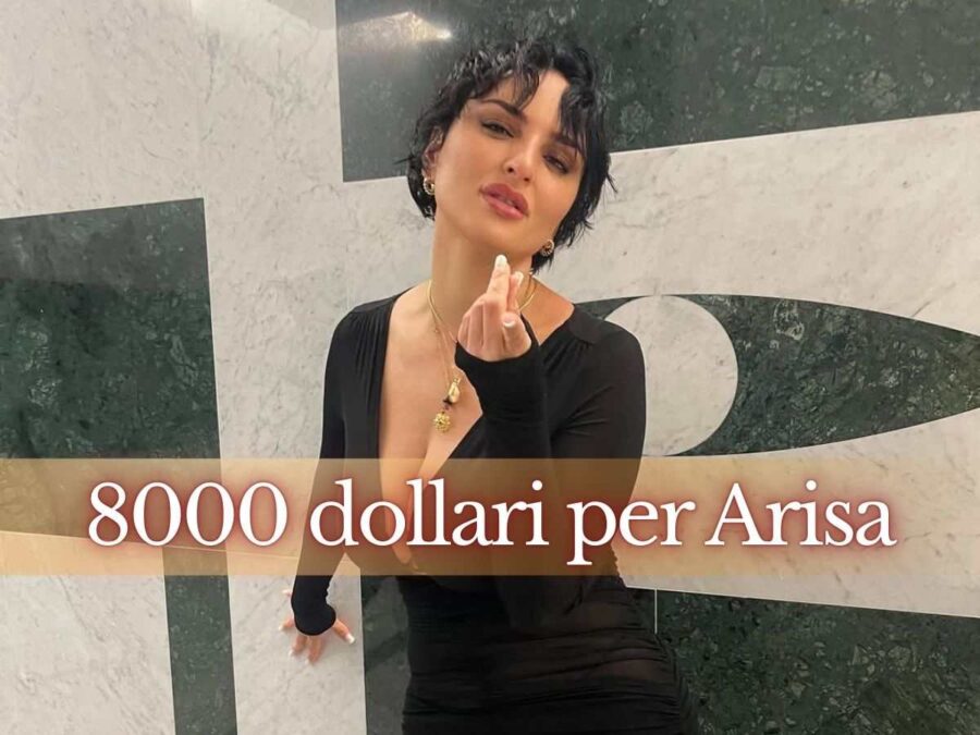 arisa in posa mentre guarda obiettivo con un abito nero scollato