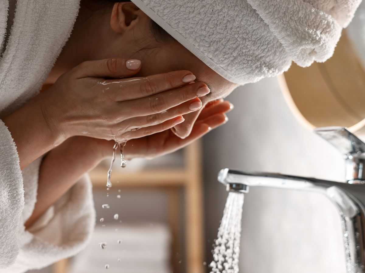donna in accappatoio sciacqua il viso