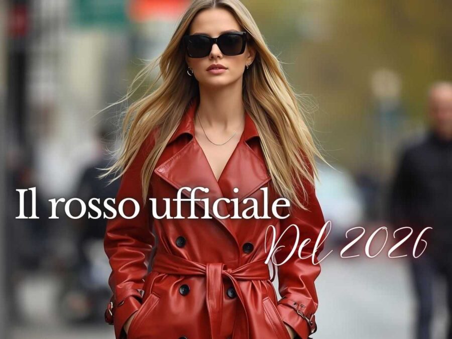 una modella sfila per strada indossando un trench di pelle rosso