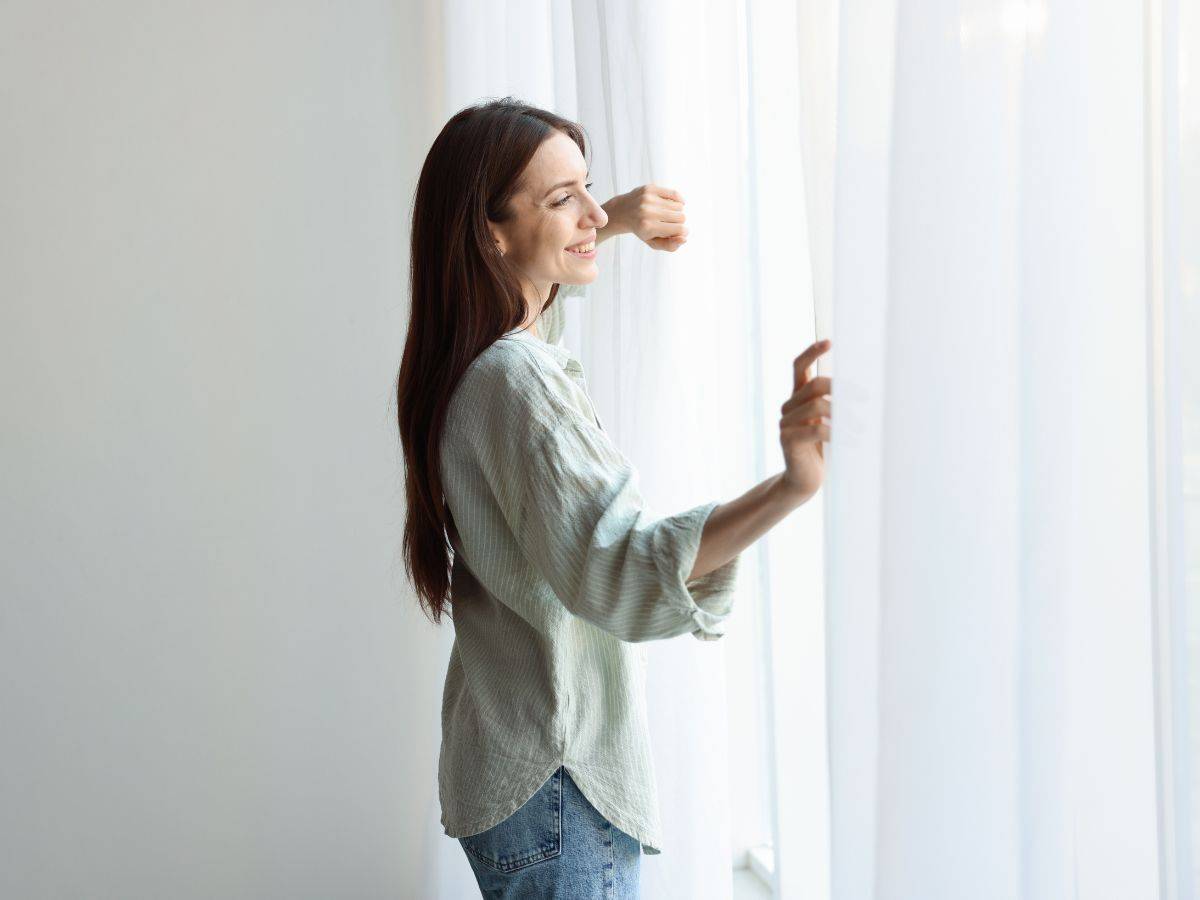 donna sorridente alla finestra